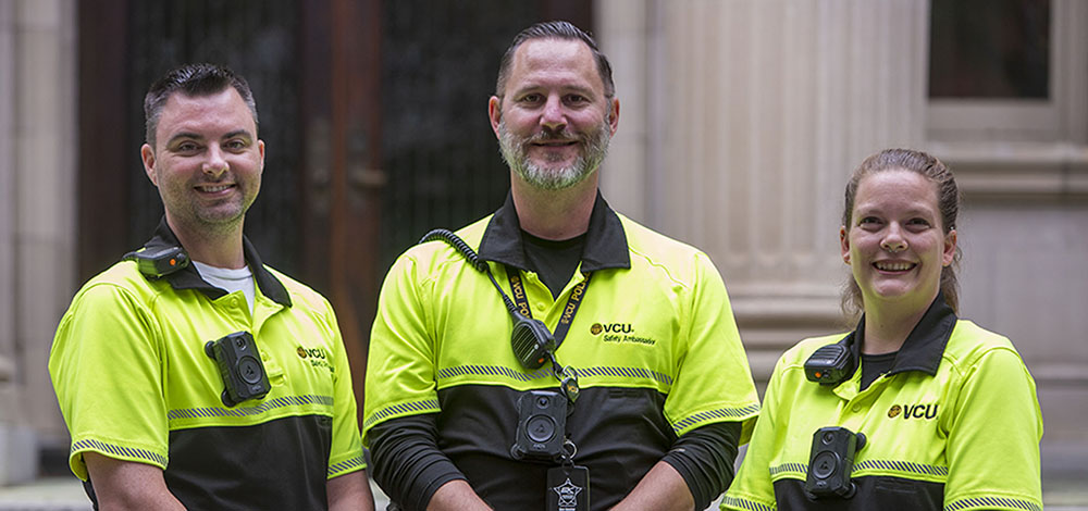 Three V-C-U safety ambassadors stand in front of the Scott House on the Monroe Park Campus.