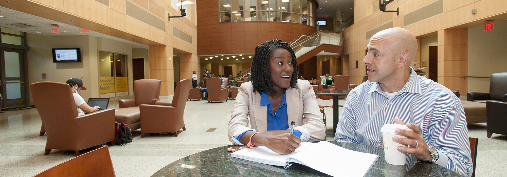 Employee and student discuss class work in Snead Hall